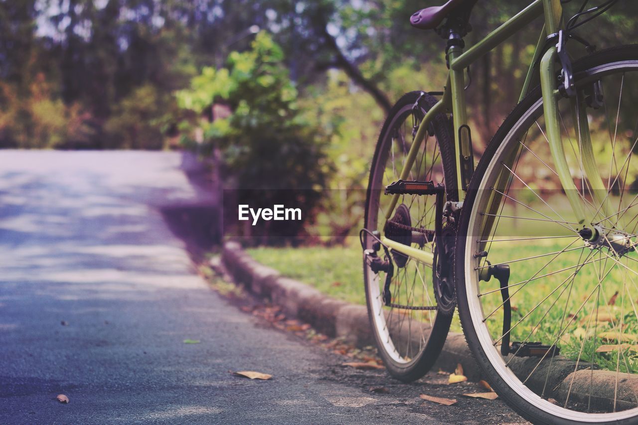 CLOSE-UP OF BICYCLE BY ROAD