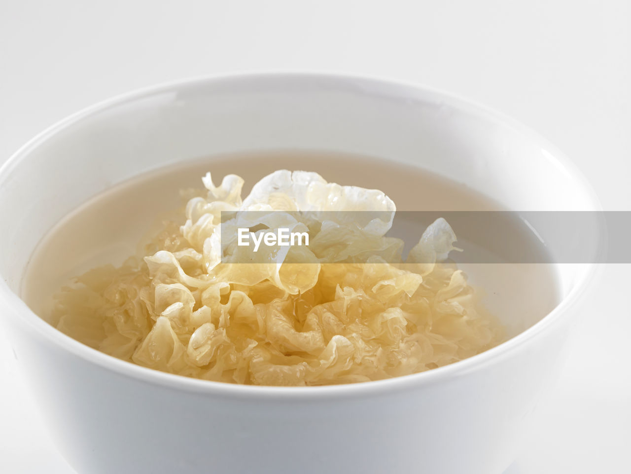 CLOSE-UP OF SOUP IN BOWL WITH WHITE BACKGROUND