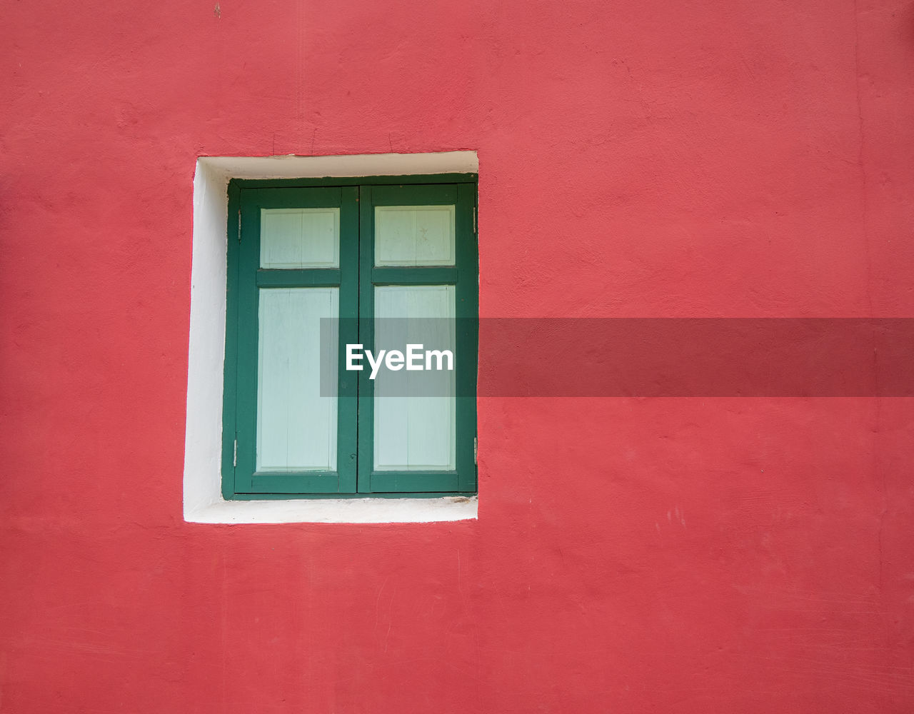 Close-up of window on red wall