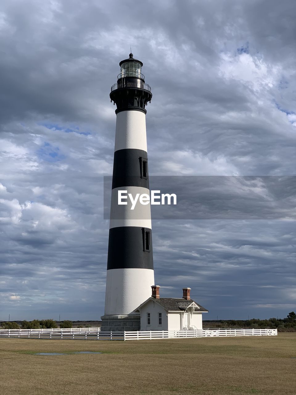 Low angle view of bodie island lighthouse against cloudy sky. cape hatteras national seashore