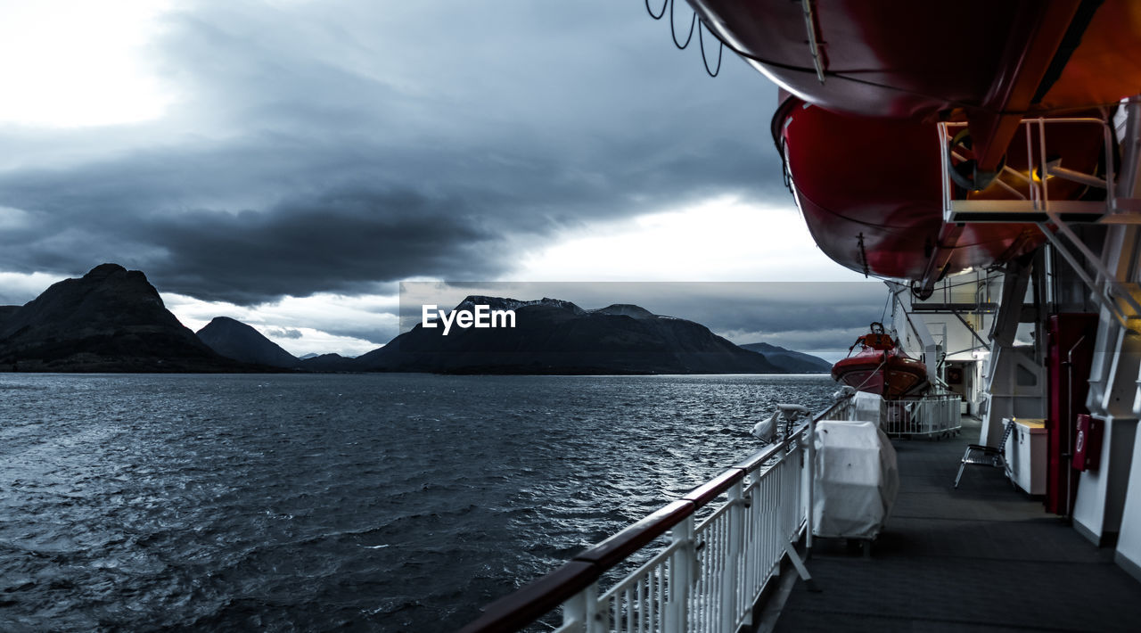 Ship in sea against cloudy sky