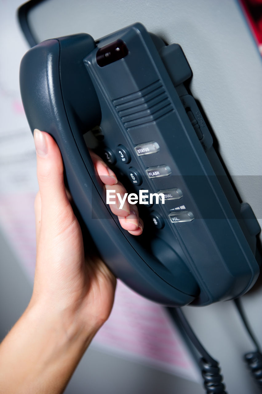 Cropped hand of woman holding telephone