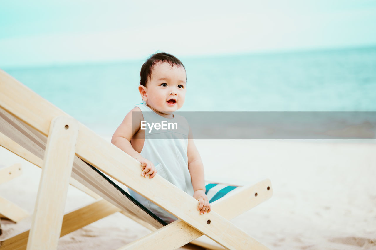 Close-up of baby sitting on beach