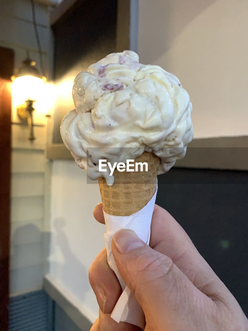 MIDSECTION OF ICE CREAM CONE AGAINST WHITE BACKGROUND