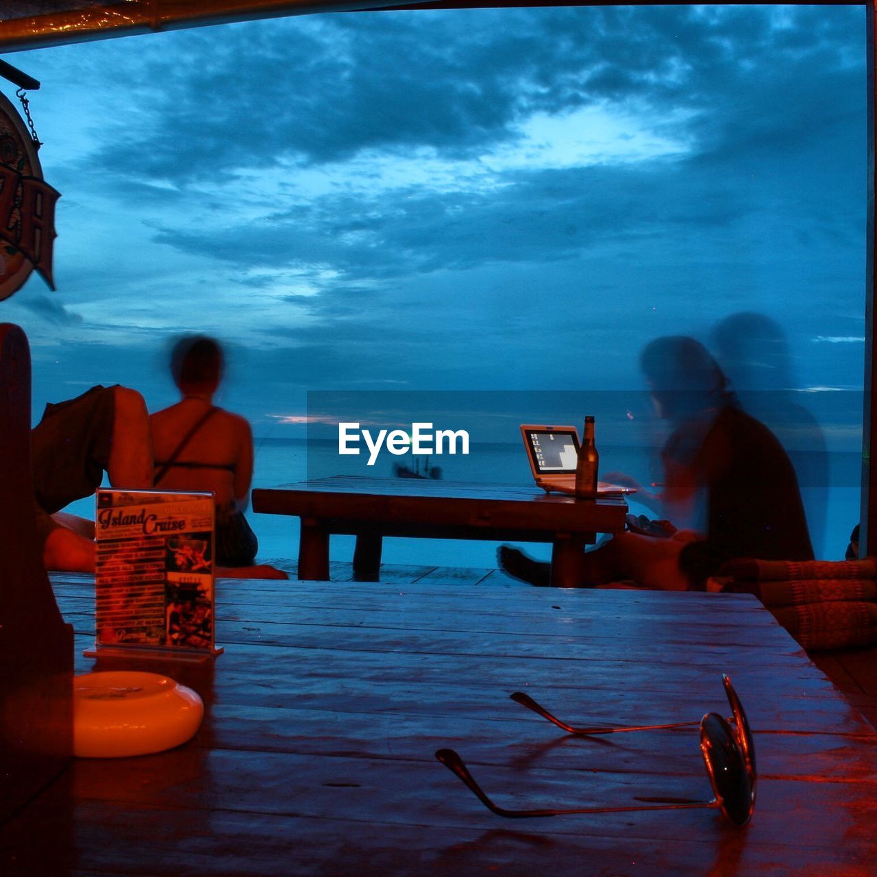 People at table on beach during dusk
