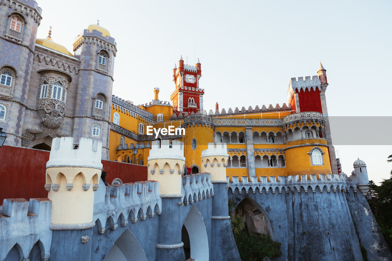 Ancient castle with bright colorful walls located against cloudless evening sky in portugal