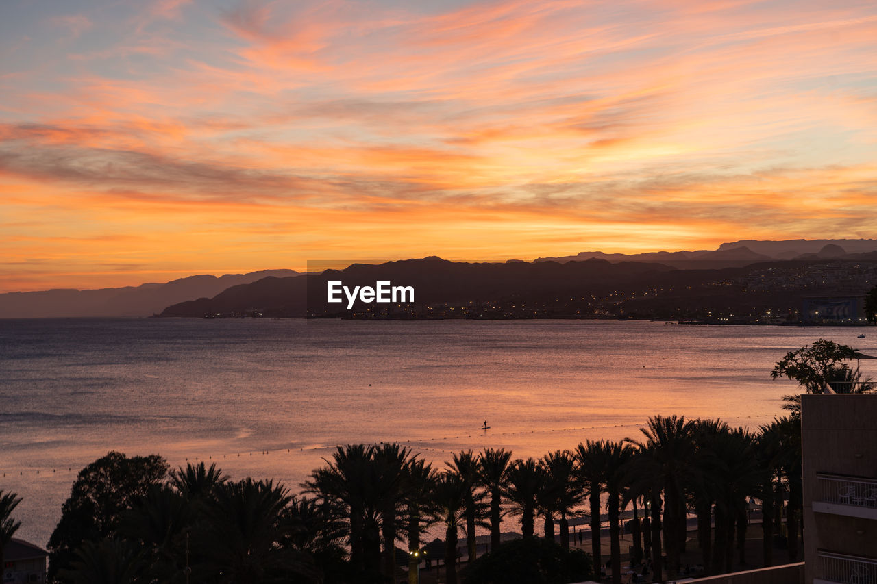 sky, water, sunset, sea, beauty in nature, nature, cloud, scenics - nature, evening, tranquility, dawn, environment, land, tree, travel destinations, tranquil scene, mountain, beach, afterglow, no people, landscape, horizon, travel, plant, orange color, coast, outdoors, sun, architecture, silhouette, tourism, dramatic sky, vacation, trip, holiday, idyllic, ocean, sunlight, red sky at morning, romantic sky, reflection, seascape