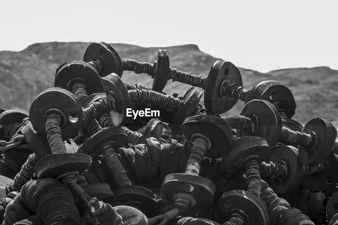 Black and white photo of fishing gear piled up next to mountain