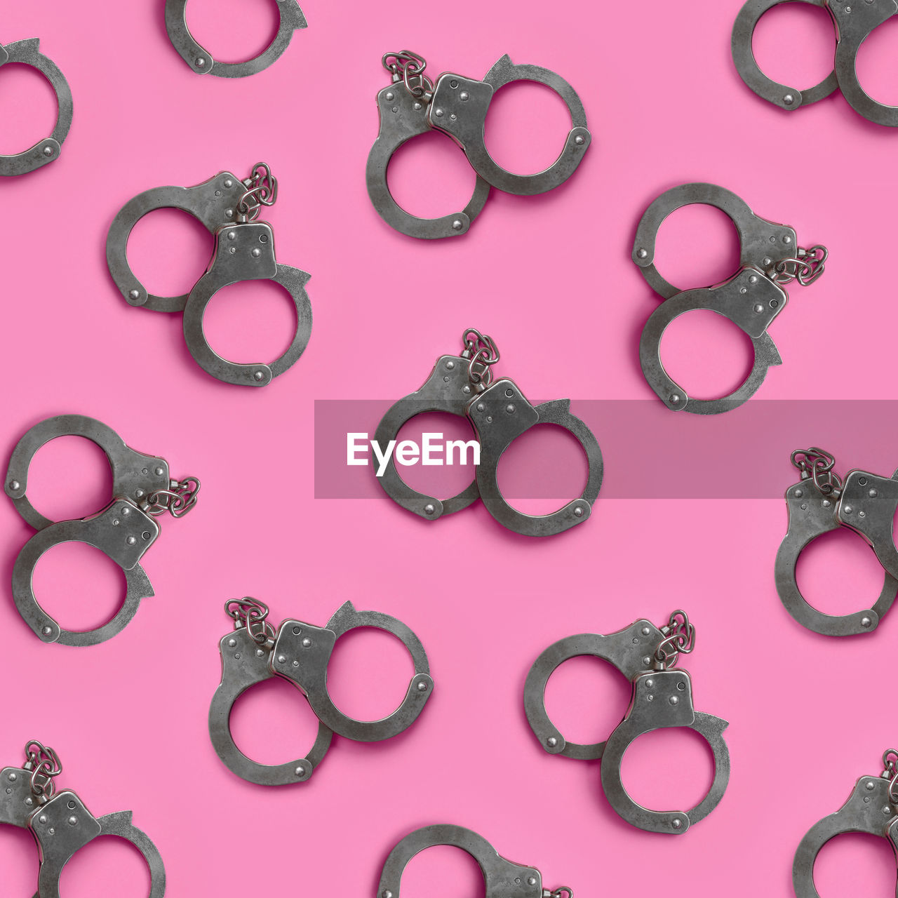 Full frame shot of handcuffs on pink table