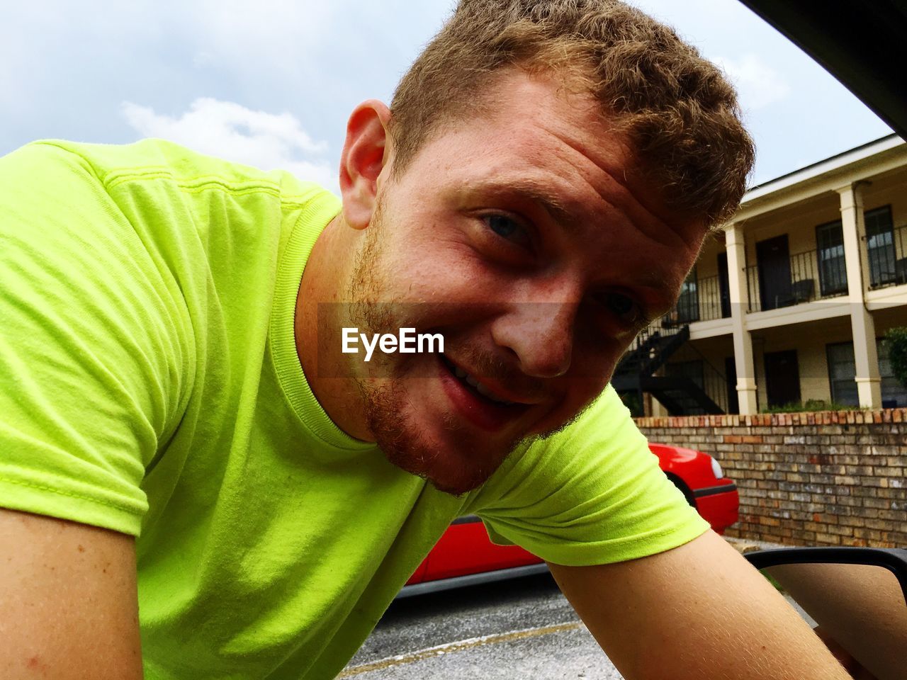 Close-up portrait of young man by car