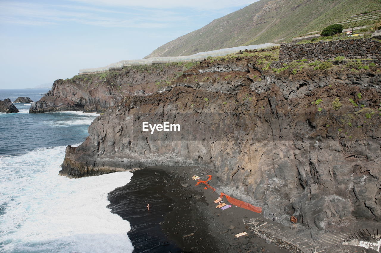 Scenic view of rock formation in sea against sky