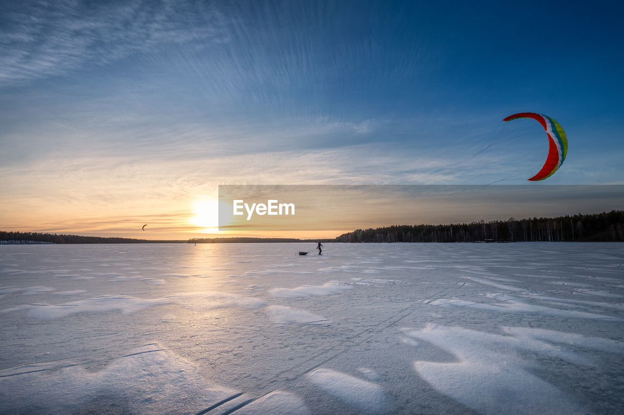 SCENIC VIEW OF SNOWY FIELD DURING SUNSET