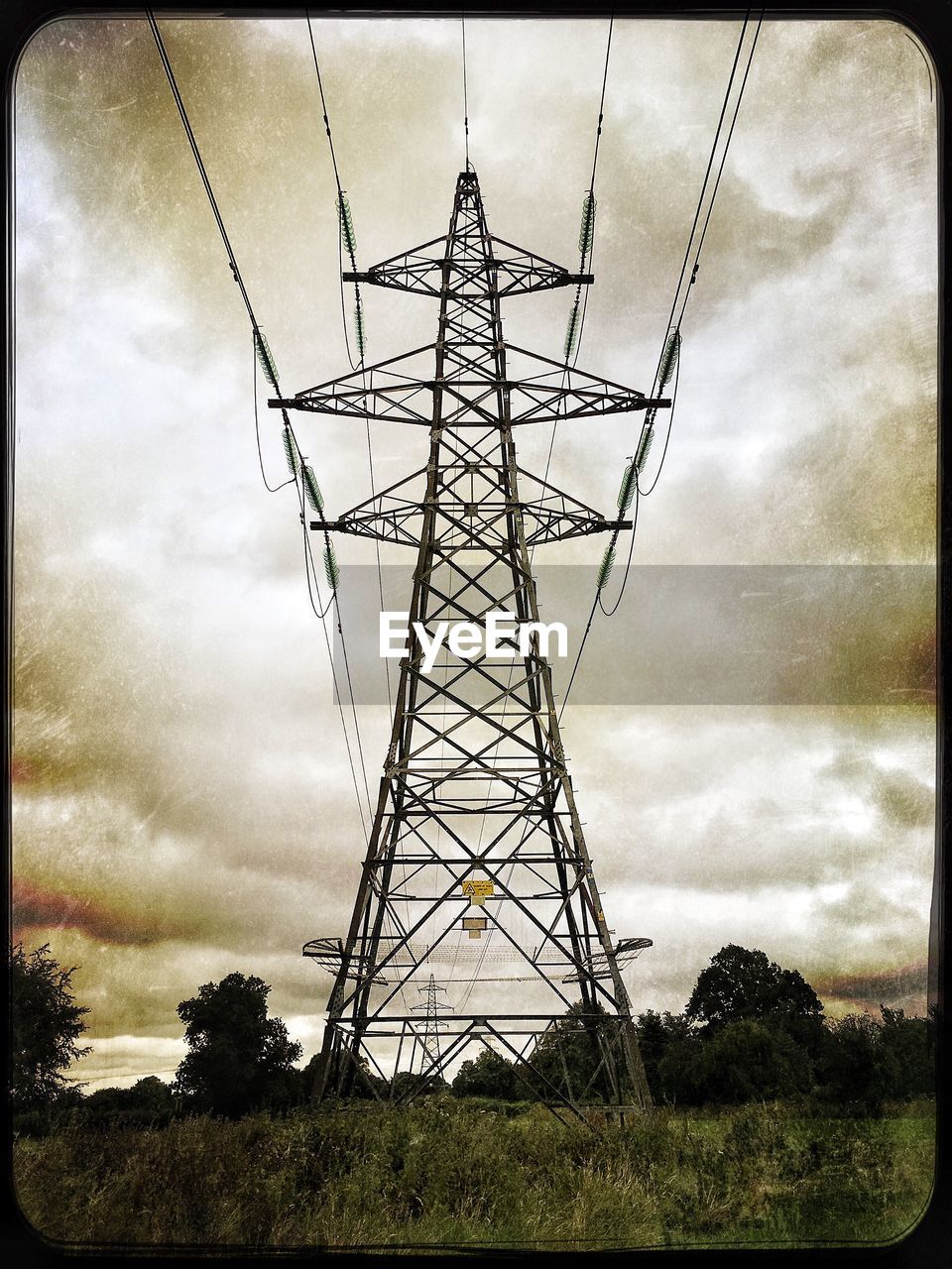 LOW ANGLE VIEW OF ELECTRICITY PYLONS AGAINST CLOUDY SKY