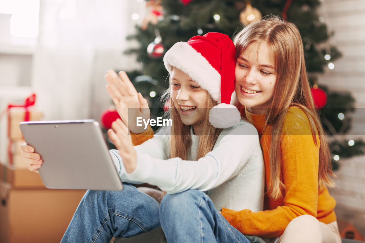 Two teenage girls with blonde european looks chat with friends and grandparents 