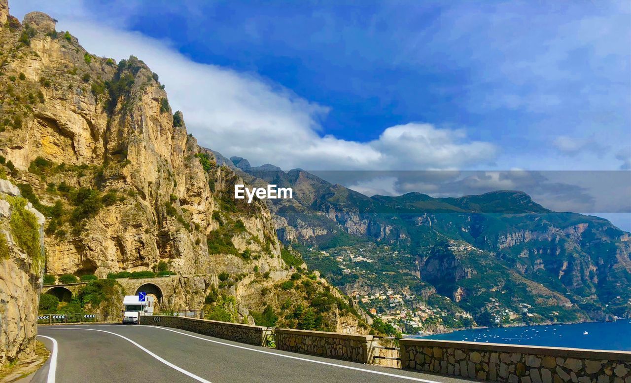 Road by mountain against sky