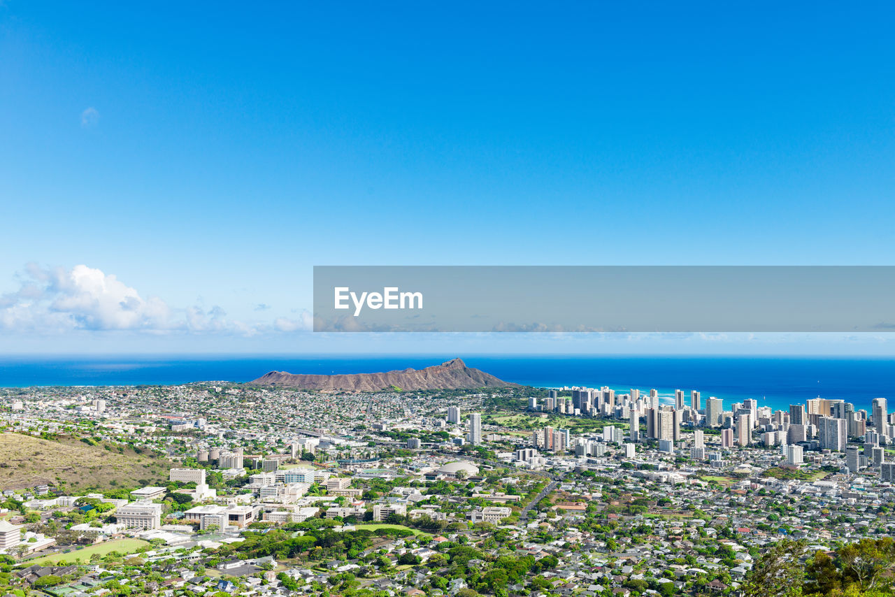 High angle view of cityscape by sea against clear sky