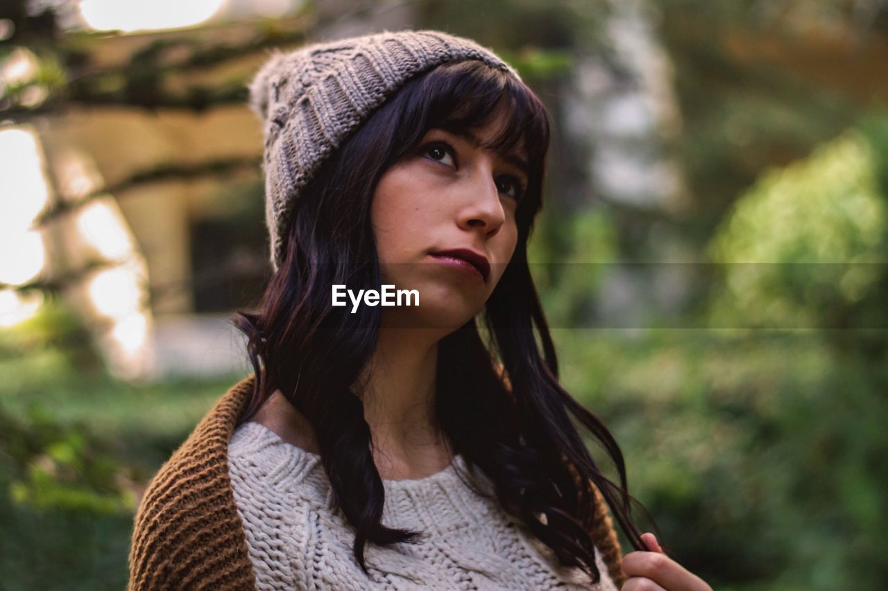 Close-up of thoughtful young woman standing outdoors