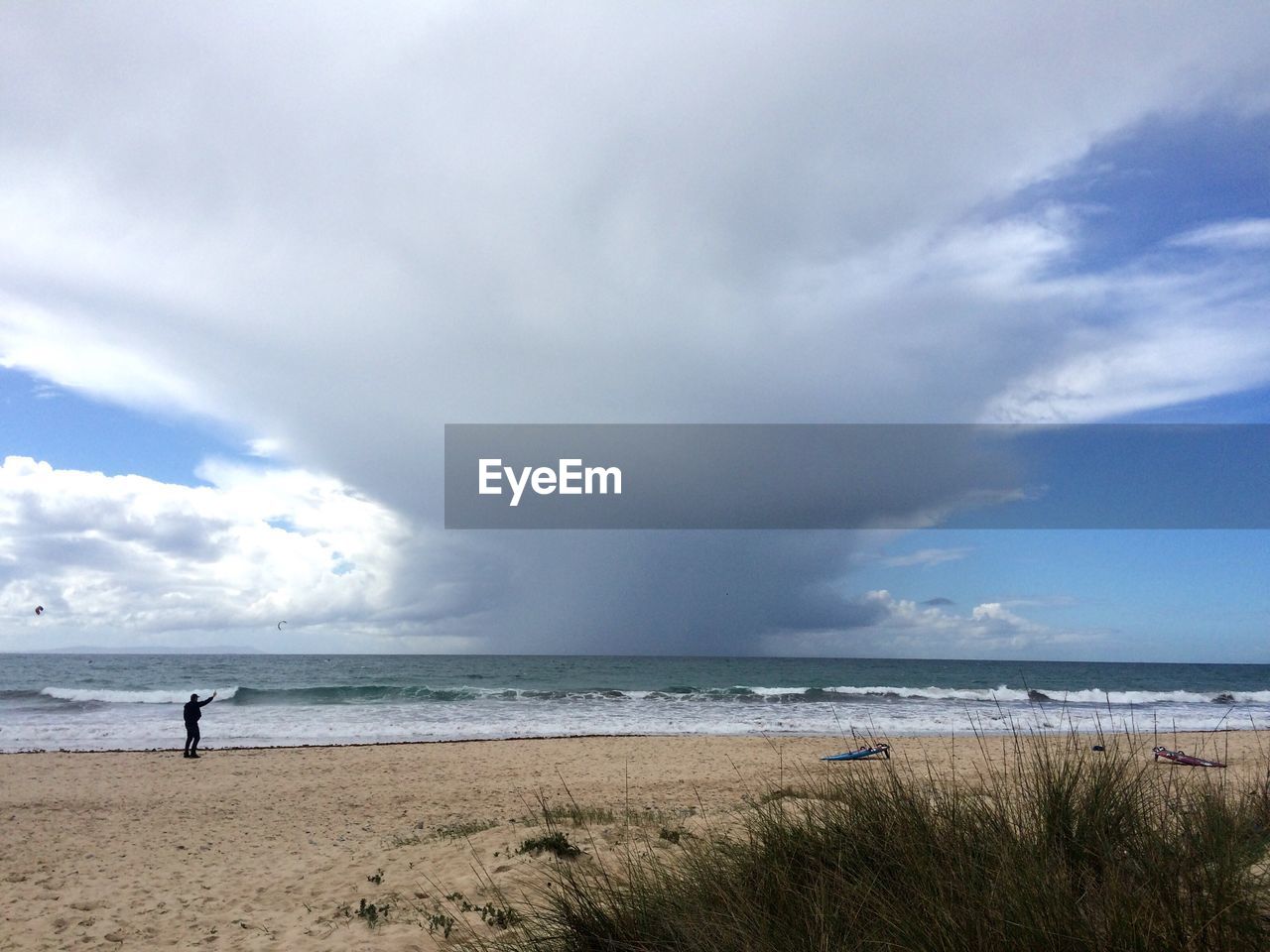 Scenic view of beach against cloudy sky