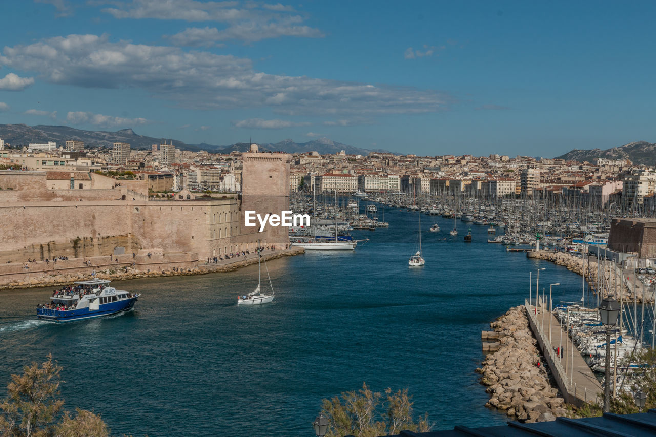 View of buildings in sea against cloudy sky