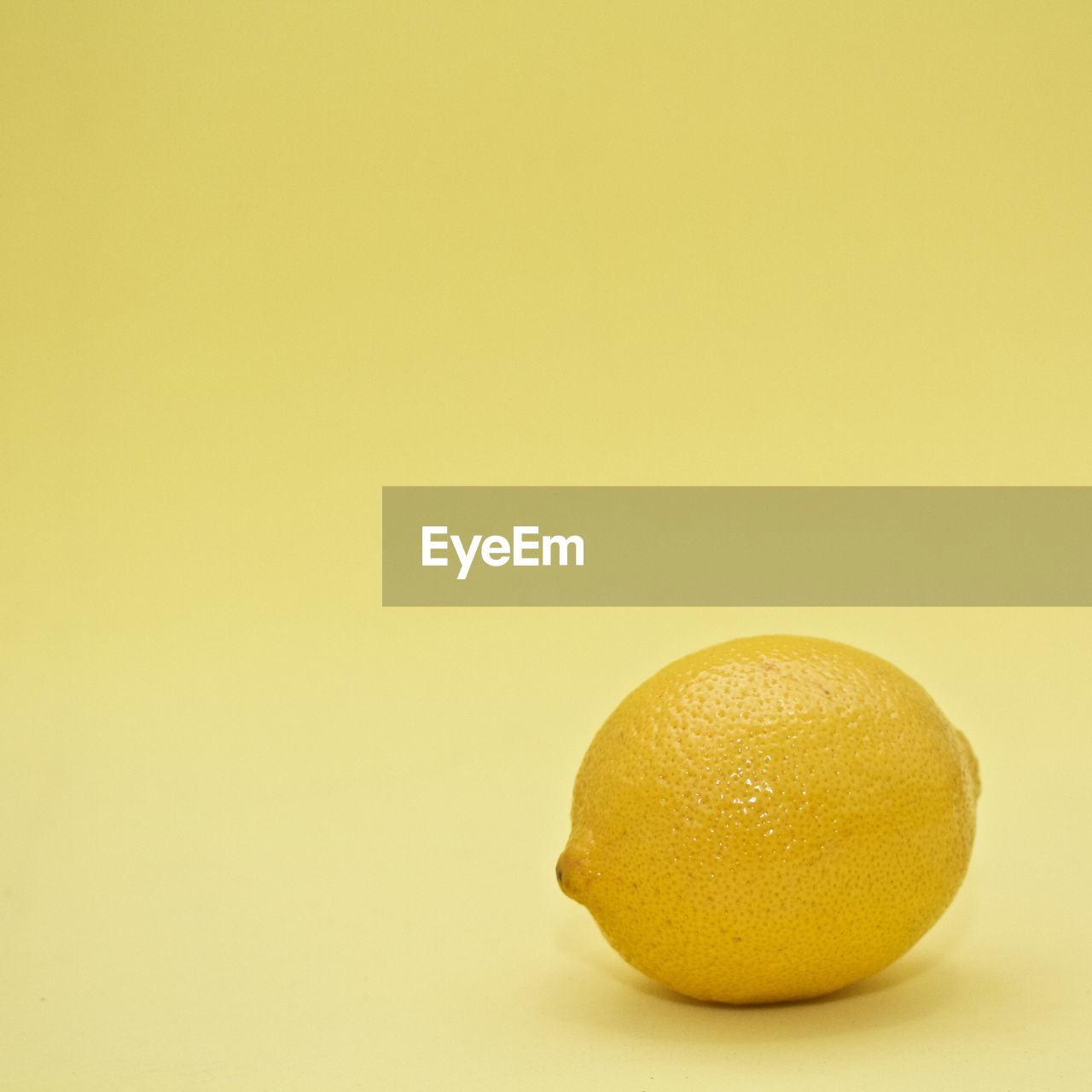Close-up of lemon on yellow background