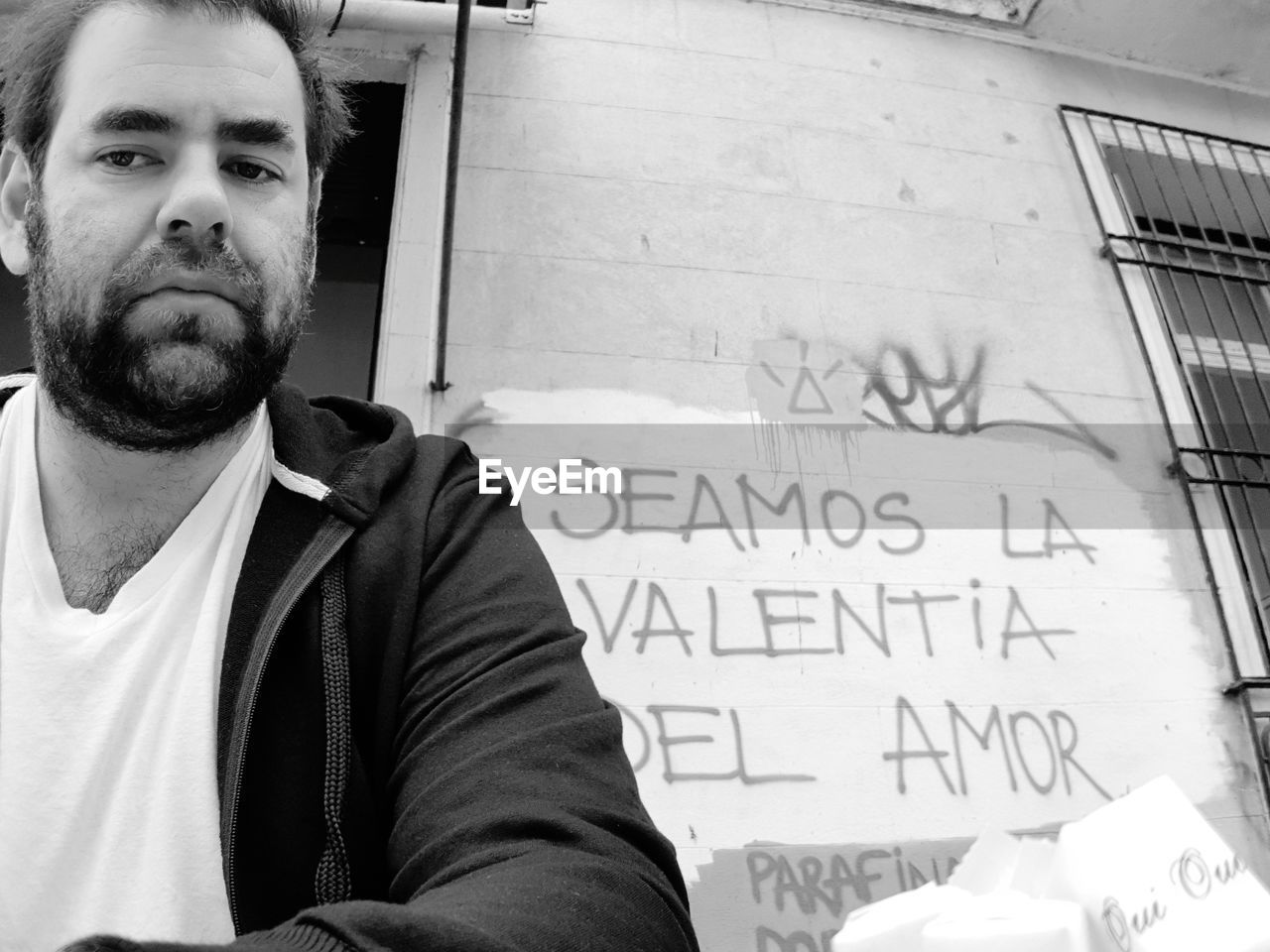Portrait of man by wall with text