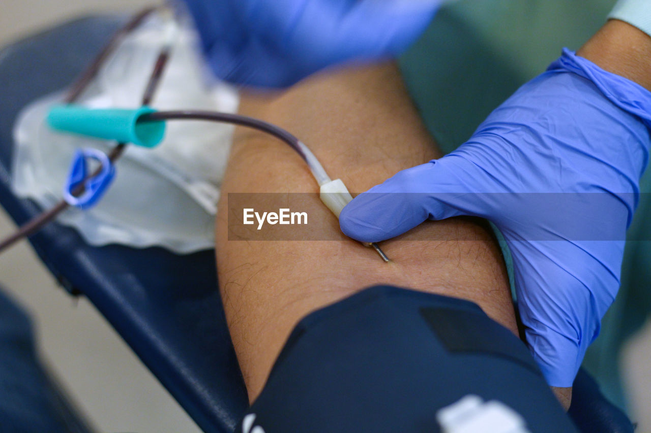 Cropped image of doctor preparing patient for blood donation