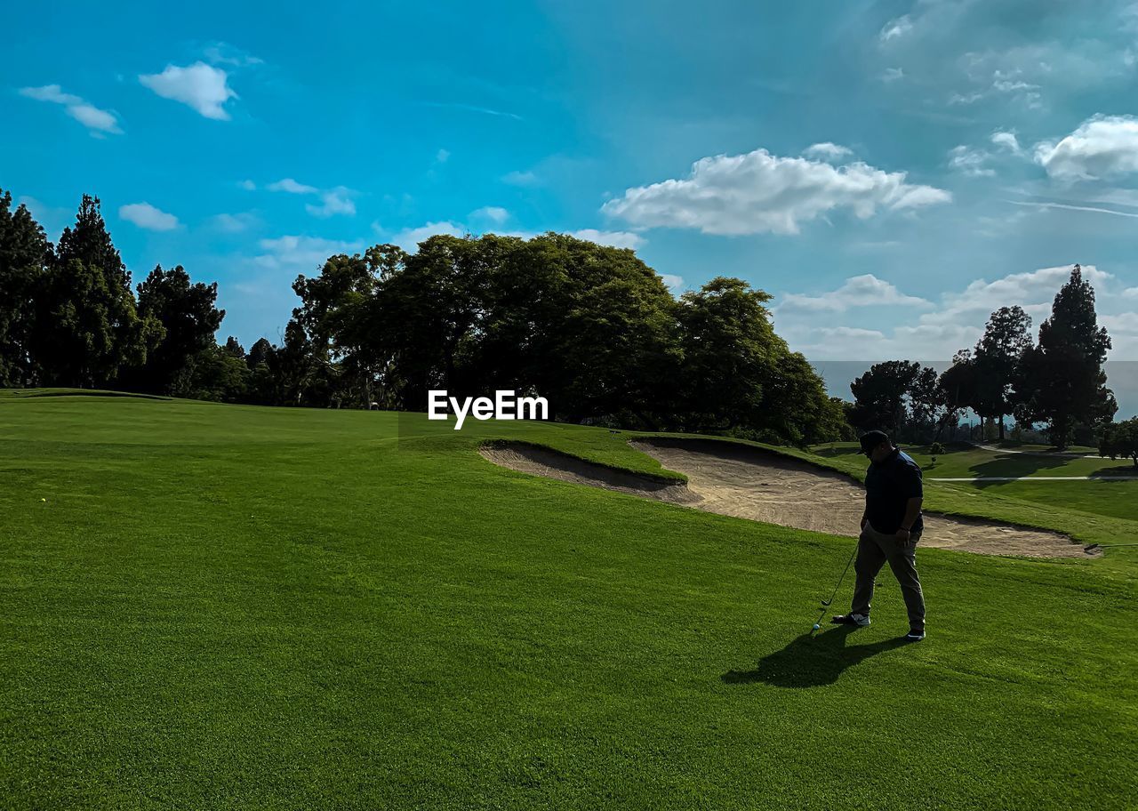 Man playing golf against sky