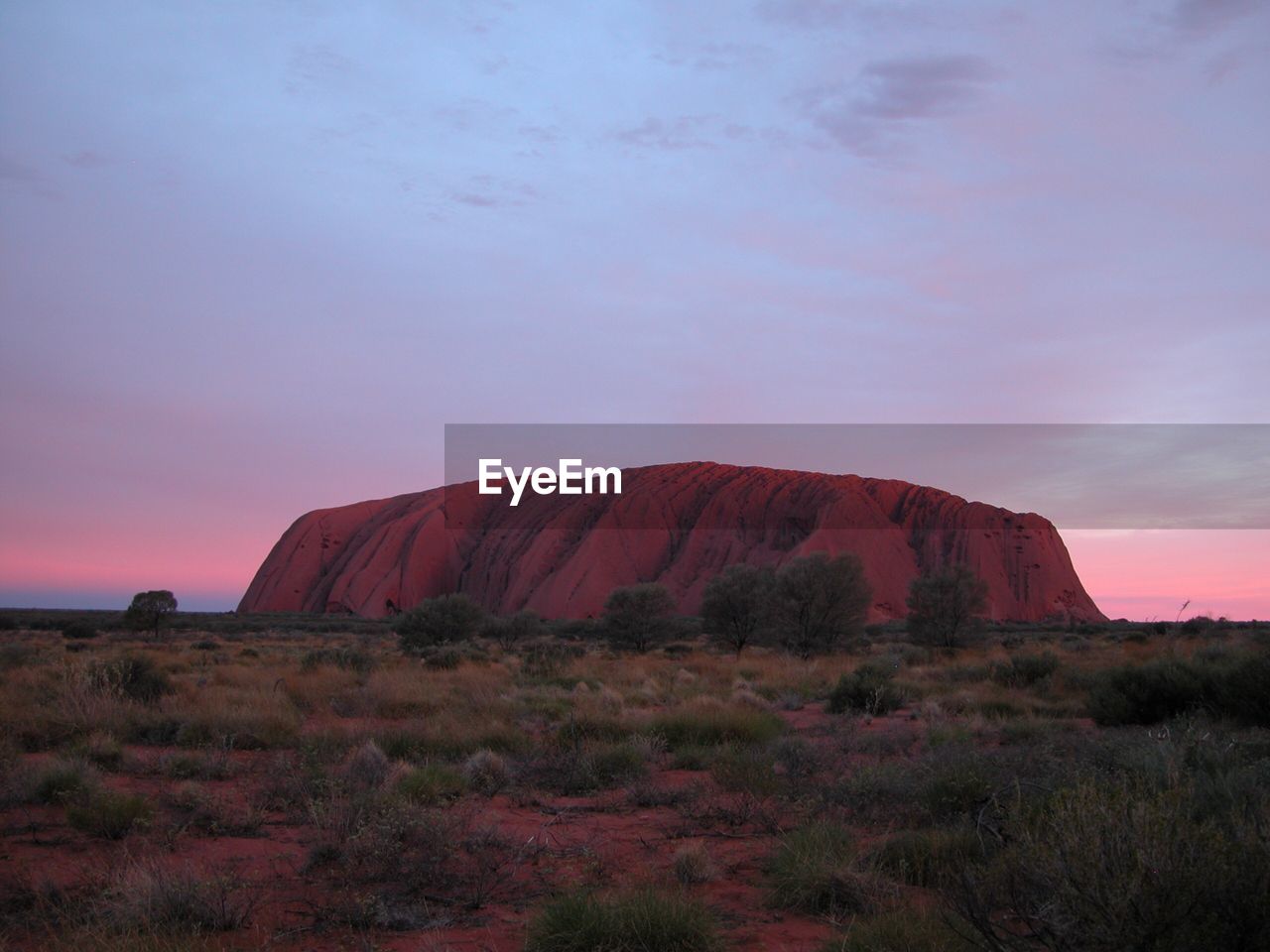 ROCK FORMATIONS ON FIELD AGAINST SKY