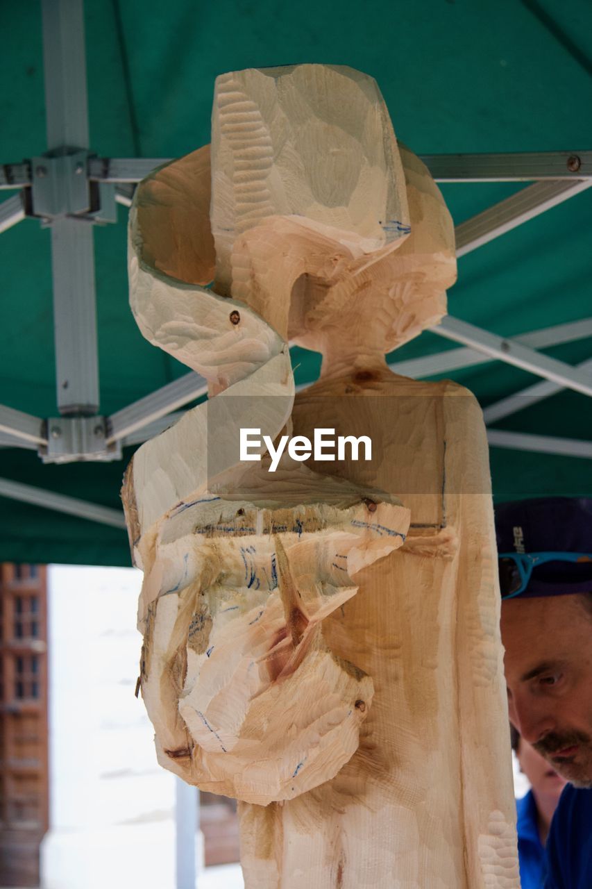 CLOSE-UP OF MAN SCULPTURE IN CONTAINER