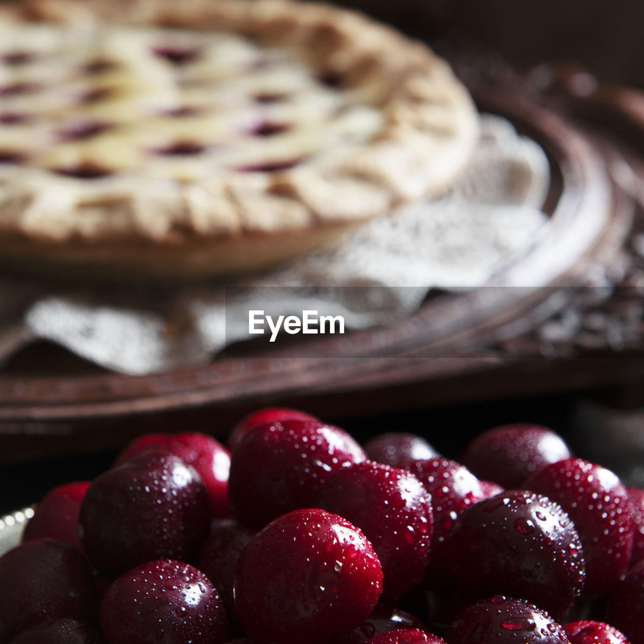 Fresh cherries ,cooked pie in the background blured for text overlay