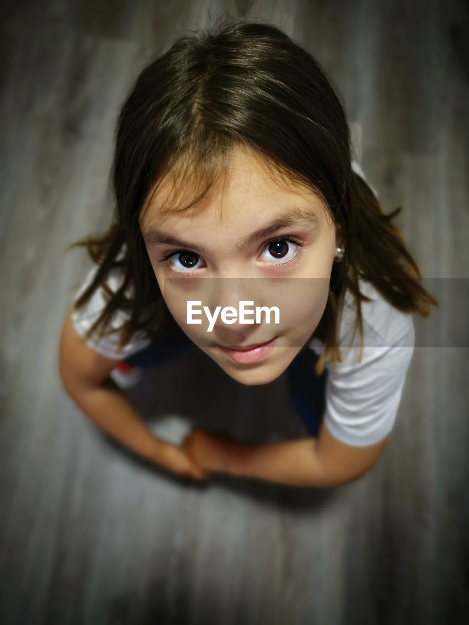 High angle portrait of cute girl crouching on floor