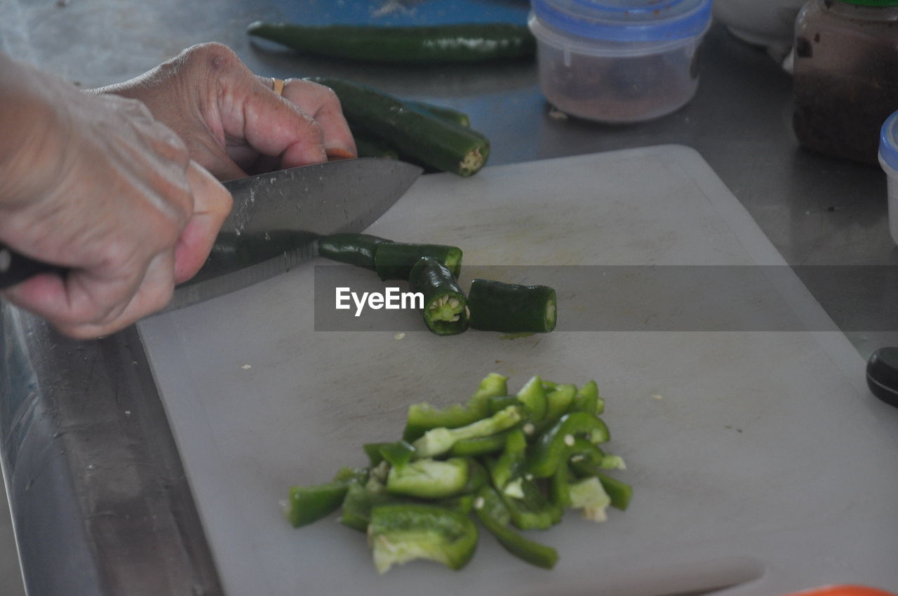 Midsection of person preparing food on cutting board