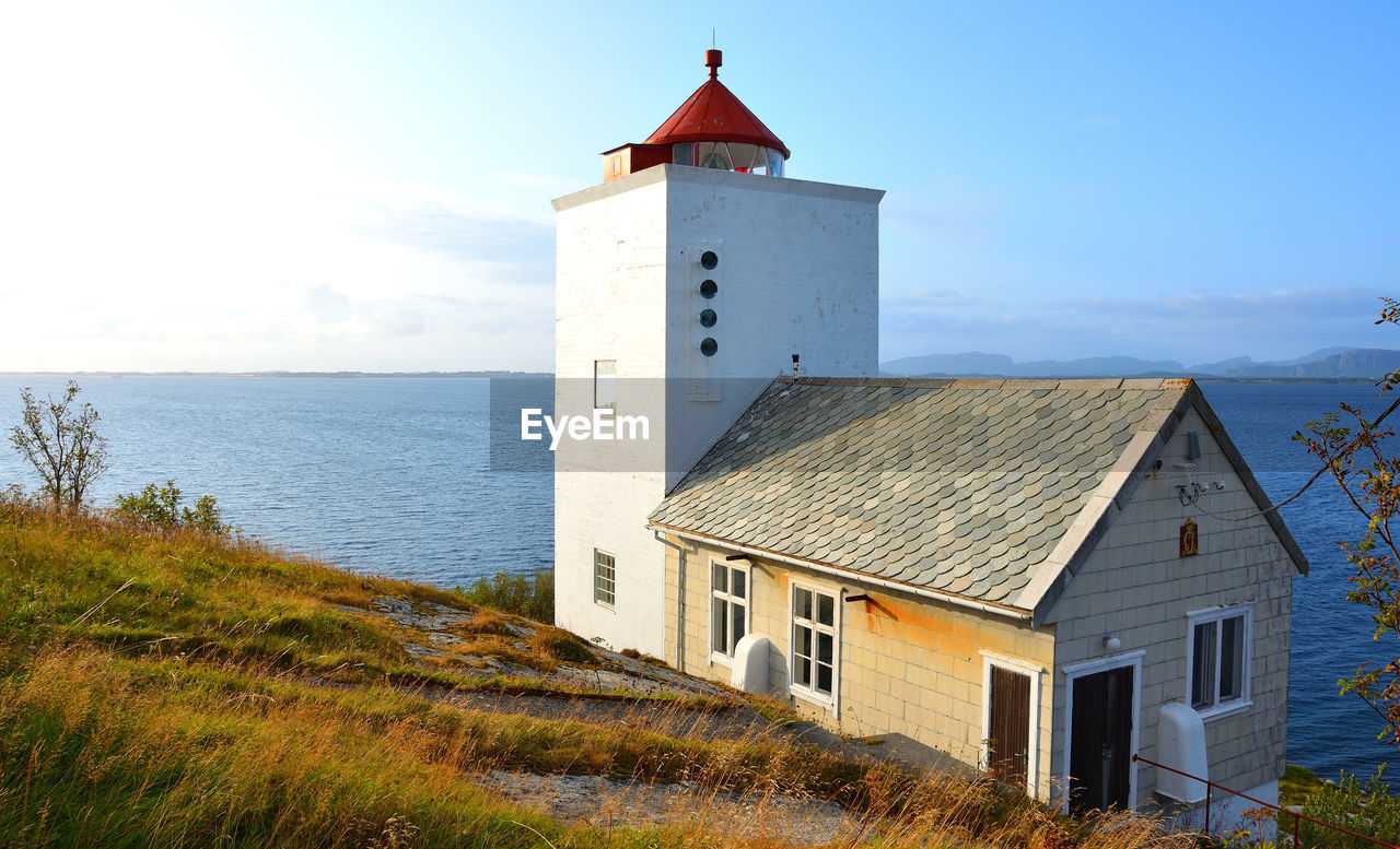 Tranquil landscape with a red and white lighthouse in norway