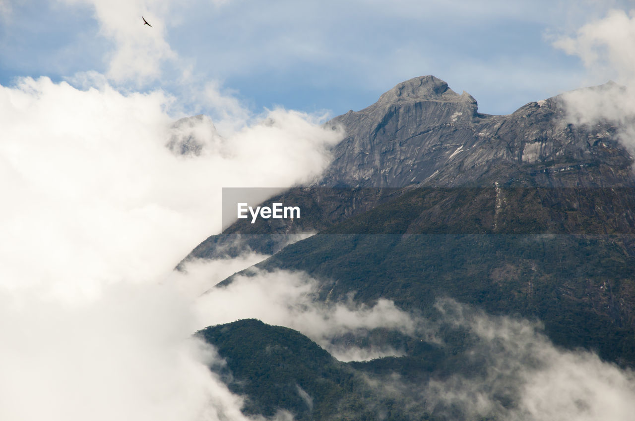 LOW ANGLE VIEW OF CLOUDS OVER MOUNTAIN AGAINST SKY