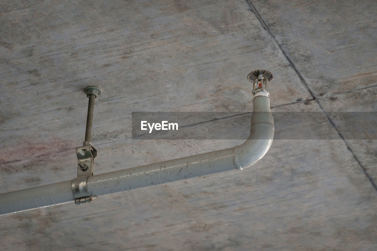 Grunge fire sprinkler or fire extinguishing system under building ceiling for emergency