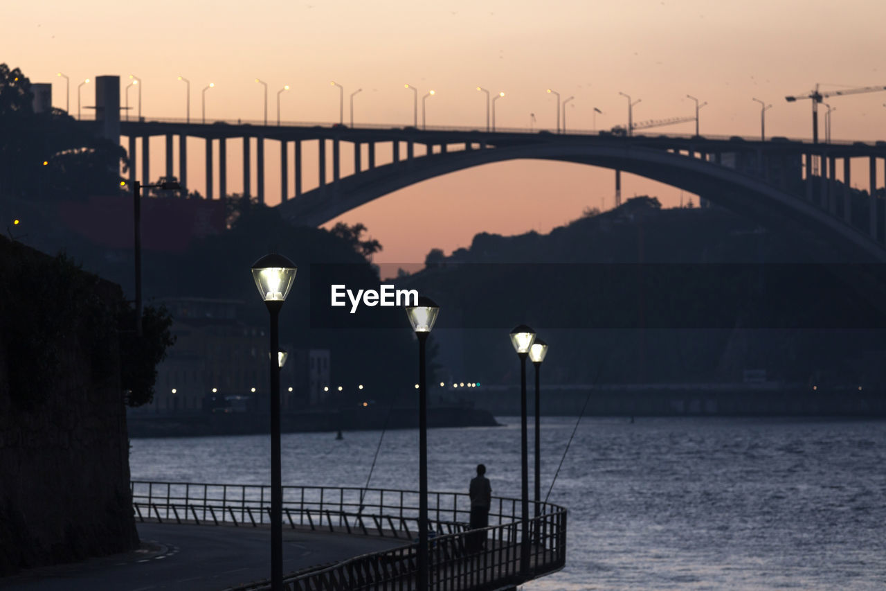 Bridge over sea against sky during sunset