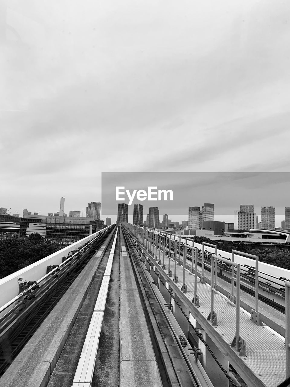 HIGH ANGLE VIEW OF RAILROAD TRACKS AGAINST CLOUDY SKY