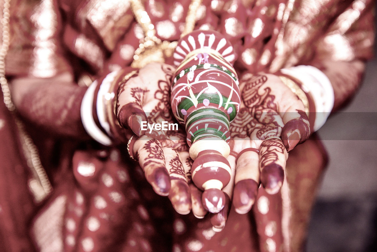 henna, pattern, henna tattoo, hand, adult, bride, women, one person, midsection, tattoo, celebration, life events, close-up, tradition, wedding, event, bracelet, newlywed, traditional clothing, jewelry, bangle, clothing, focus on foreground, ceremony, ring, indoors, wedding ceremony, lifestyles, pink, creativity, holding, finger