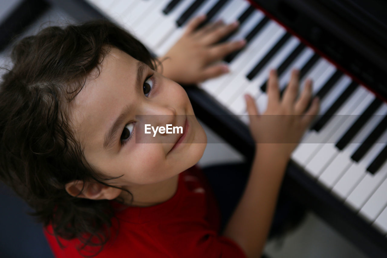 Portrait of cute boy playing piano