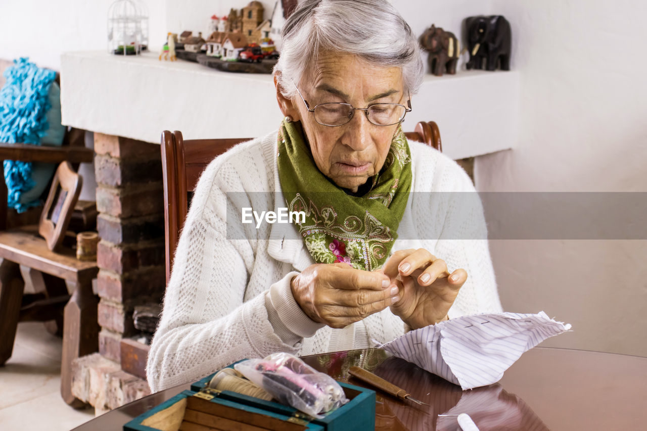 YOUNG WOMAN SITTING ON TABLE AT CAFE