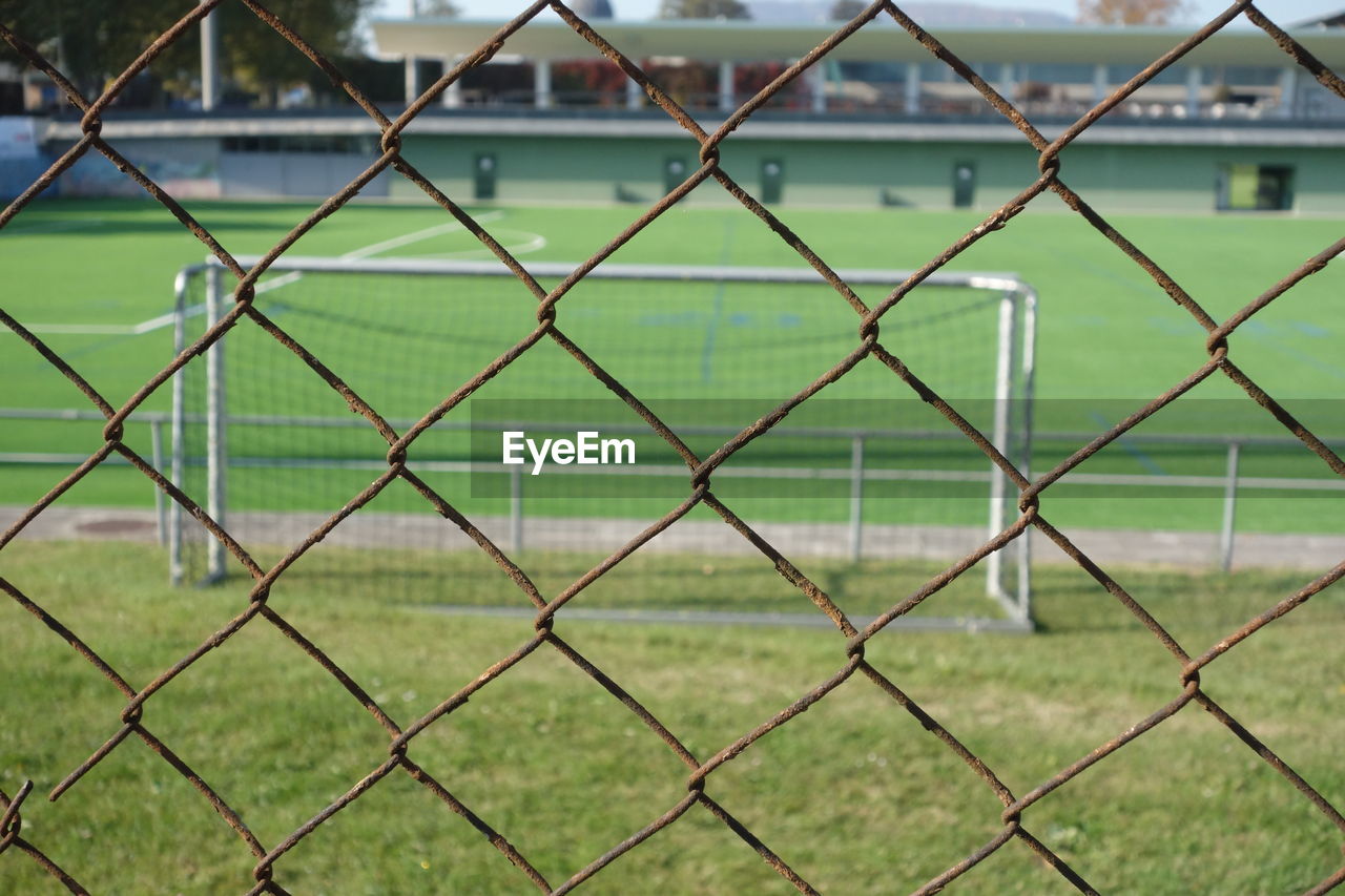 fence, chainlink fence, chain-link fencing, green, security, net, grass, sports, protection, no people, day, nature, playing field, focus on foreground, home fencing, metal, field, outdoors, full frame, soccer field, land, team sport, backgrounds, soccer, wire fencing, outdoor structure, pattern, plant