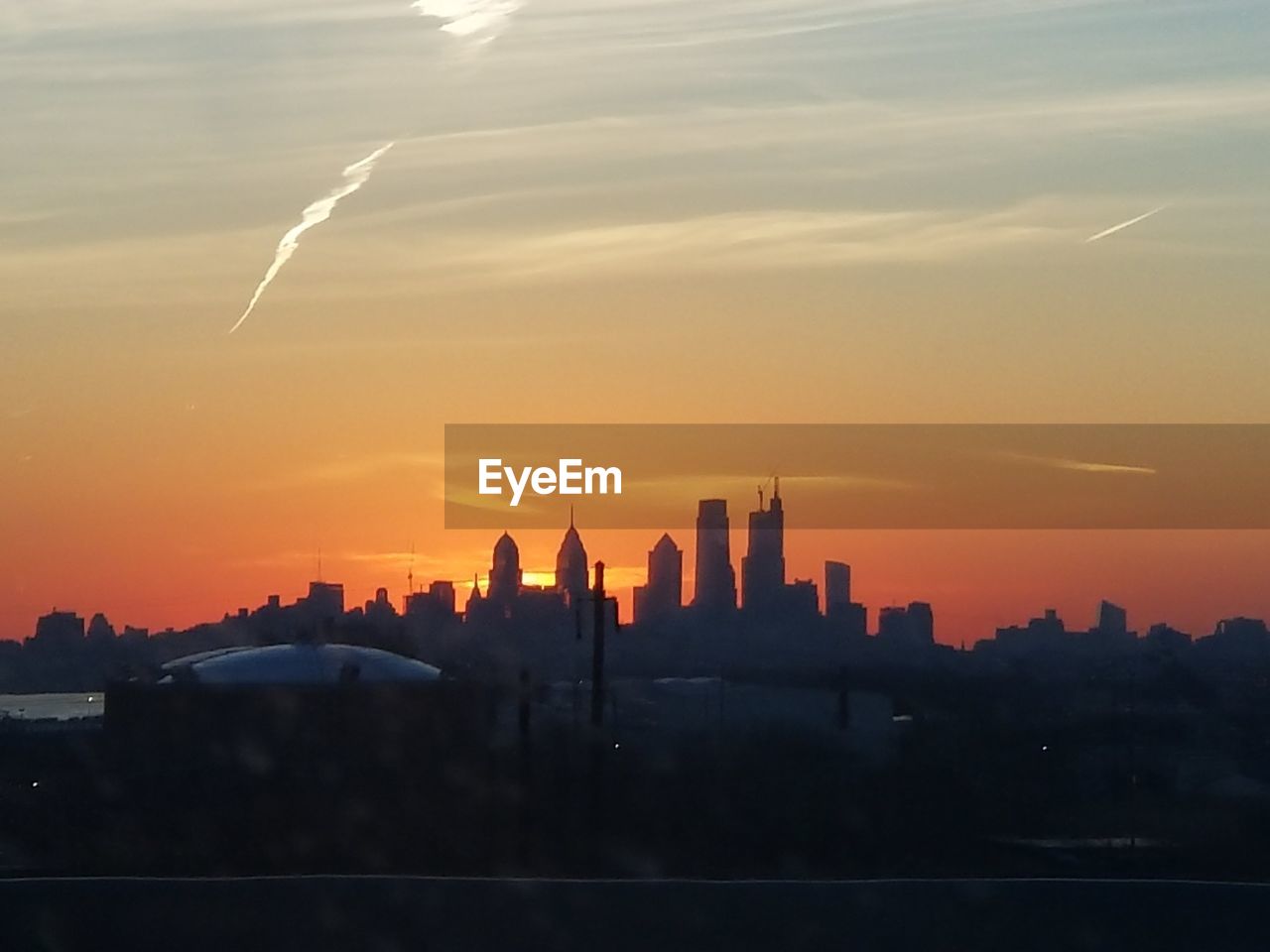 SILHOUETTE BUILDINGS AGAINST ORANGE SKY