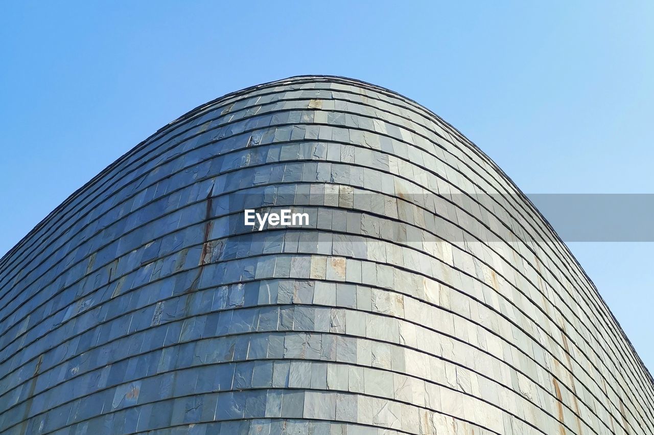 Low angle view of modern building against clear blue sky