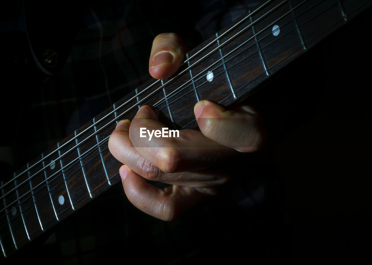 Close-up of hands playing guitar