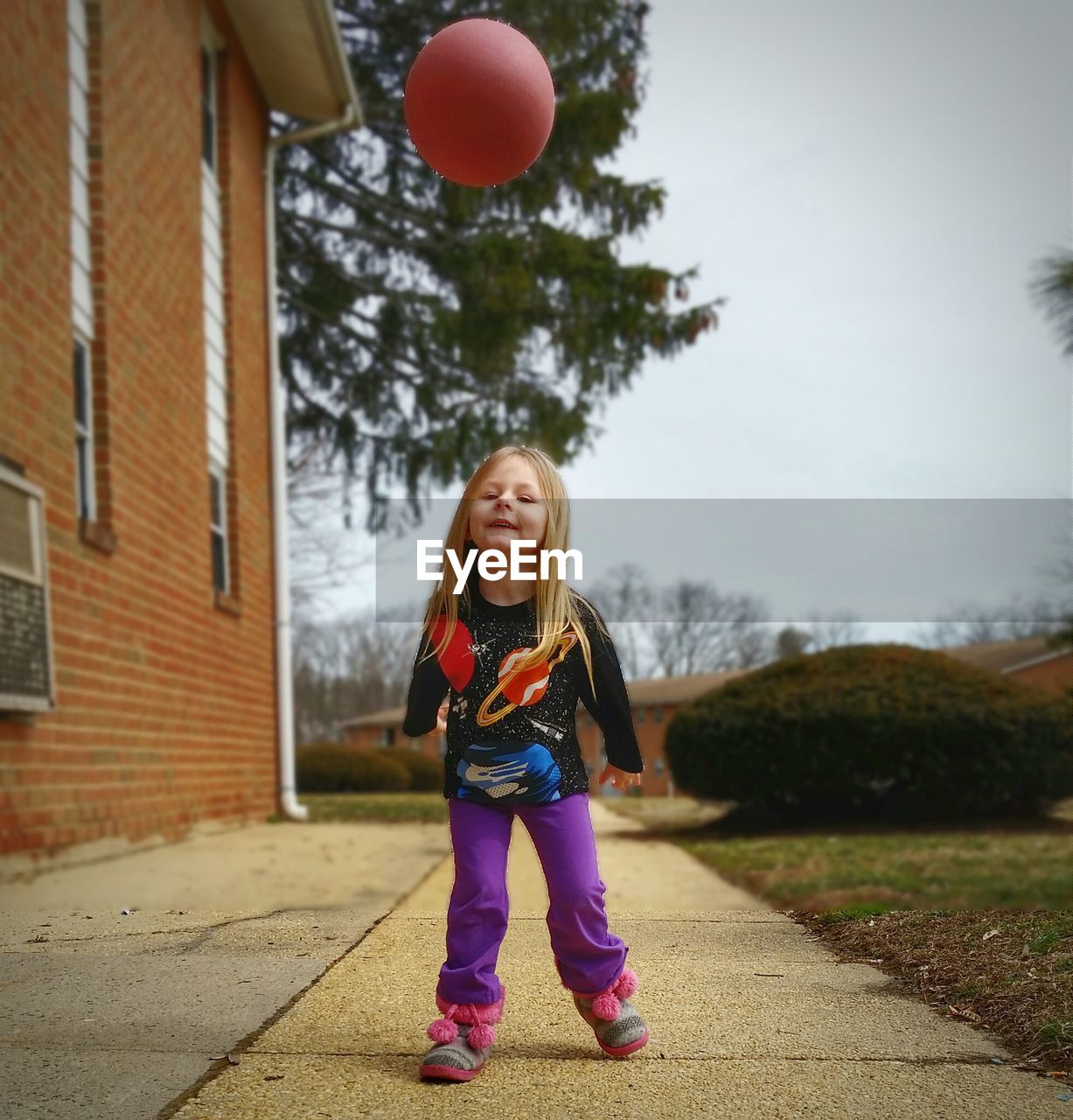 Full length portrait of cute girl playing with ball