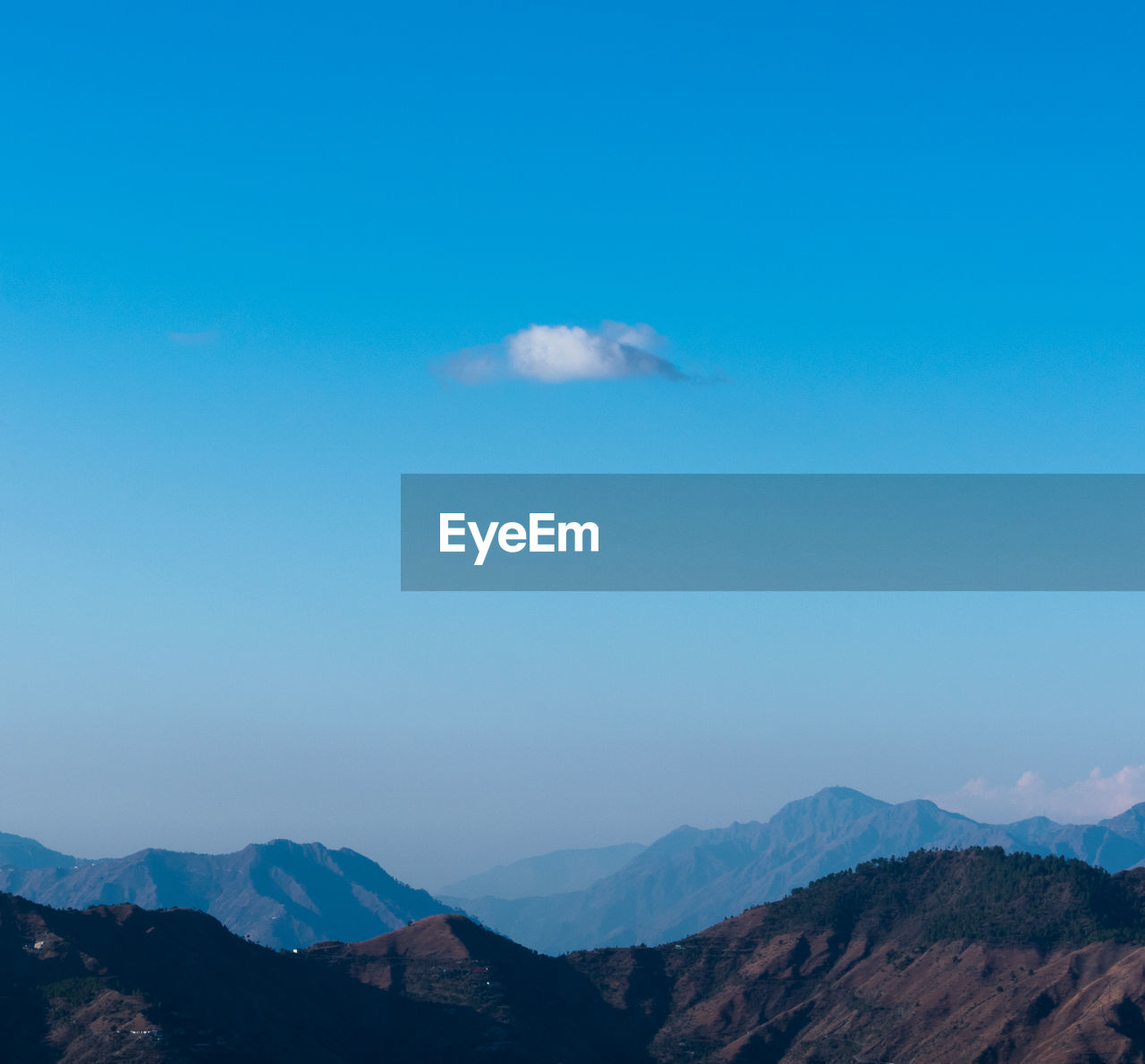 Scenic view of mountain range against blue sky