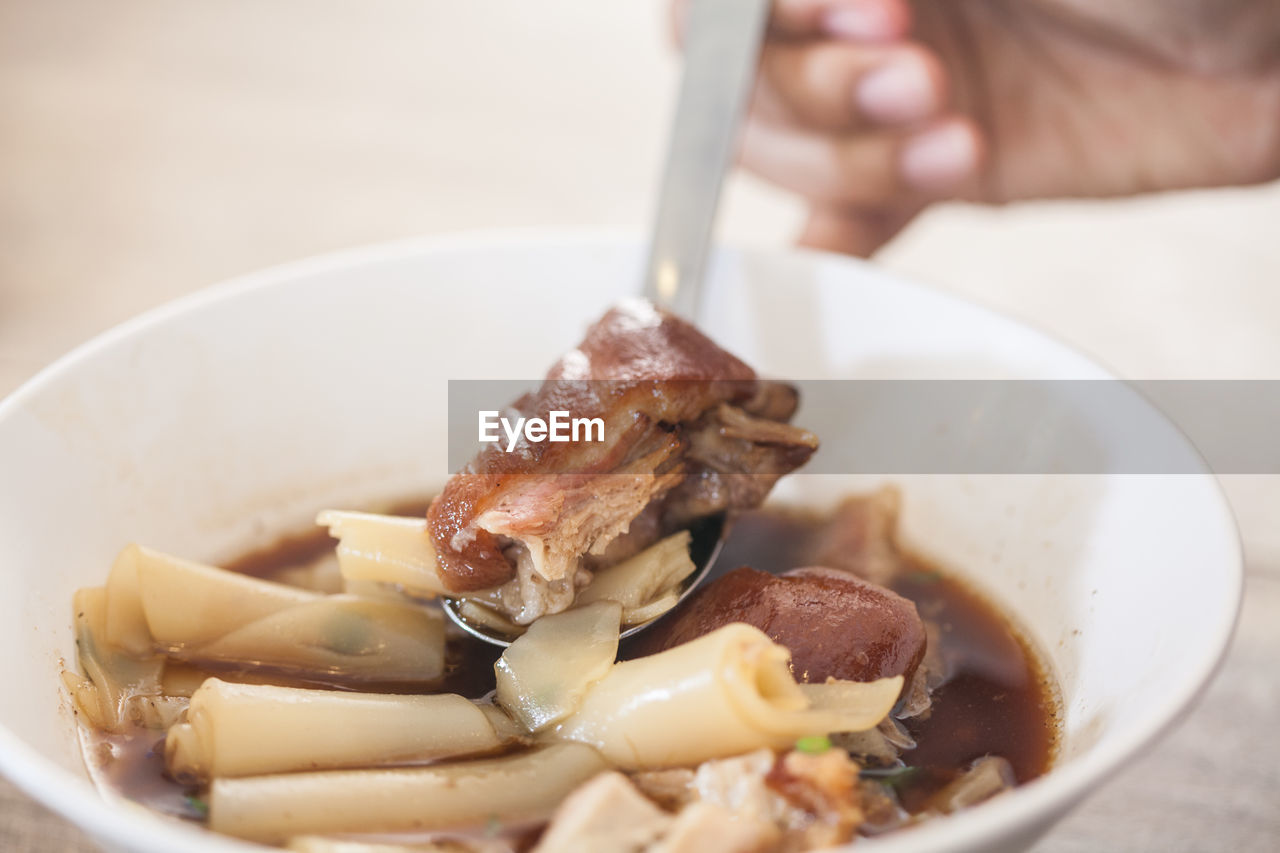 CLOSE-UP OF PERSON PREPARING FOOD IN PLATE