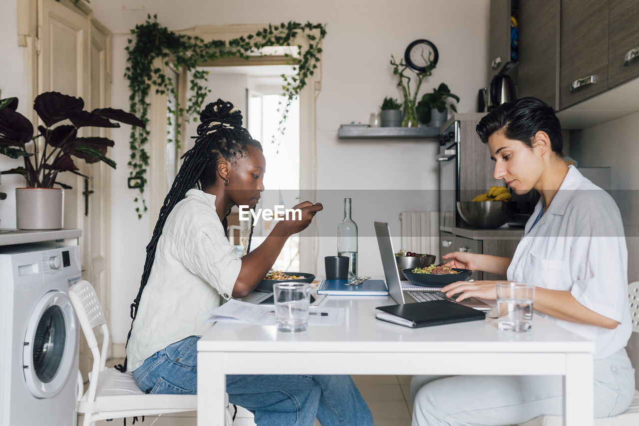 Young businesswomen having breakfast and working at home