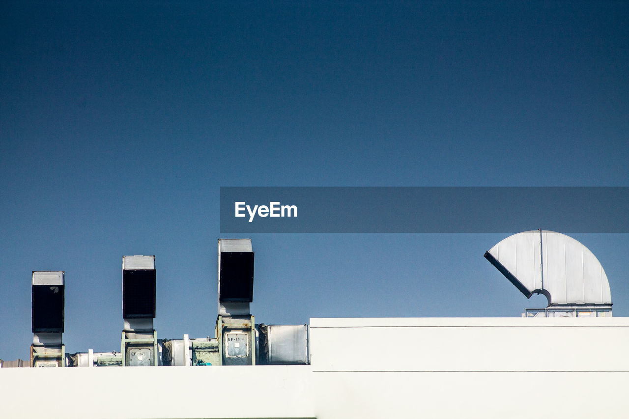 LOW ANGLE VIEW OF MODERN BUILDINGS AGAINST CLEAR BLUE SKY