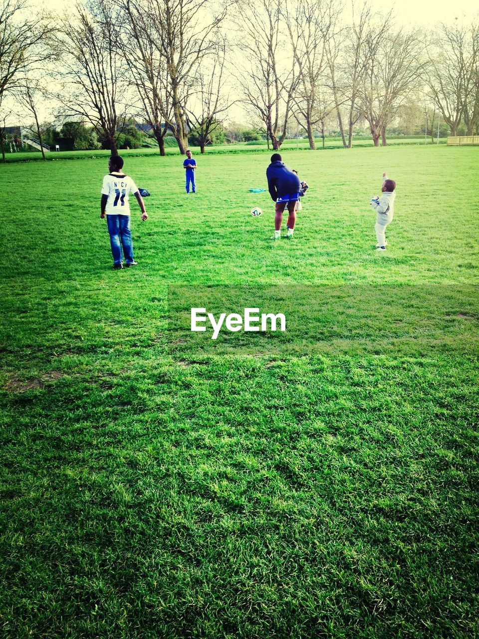 Family playing football on grassy field